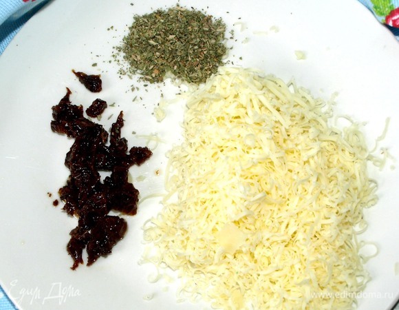 Пока батат запекается, можно приготовить остальные ингредиенты. Сыр натереть на мелкой терке, вяленые помидоры мелко нарезать.