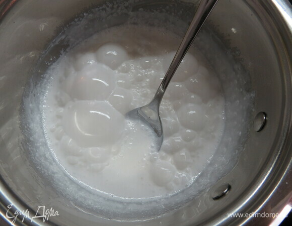 Во втором сотейнике соединяем сахар, воду и краситель (у меня базовый цвет — белый, краситель диоксид титана), нагреваем до 110°C и добавляем к молочной смеси, перемешиваем. Добавляем глюкозу и возвращаем сотейник на маленький огонь, мешаем до однородности. Убираем с огня и вводим желатин. Остужаем до 30°C.