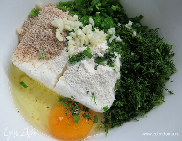 Перемешиваем творог, мелко нарезанную зелень, порубленный чеснок и соль. Добавляем яйцо, муку, натертый на крупной терке сыр и разрыхлитель. Немного сыра оставляем для посыпки. Я еще добавила 1 ст. л. псиллиума.