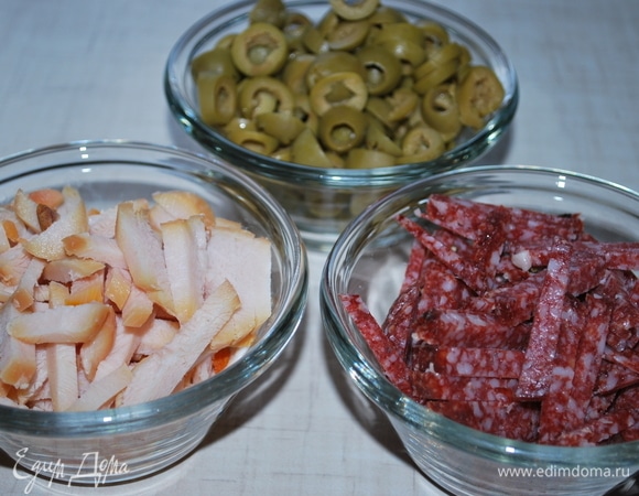 Оливки нарежьте колечками, колбасу и куриную грудку — соломкой. Можно добавить любые копчености или мясо по своему вкусу.