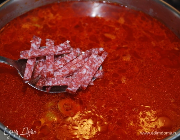 Когда картофель станет мягким, помните его хорошо толкушкой, добавьте лук с томатной пастой и морковью, все хорошо перемешайте. Добавьте оливки, колбасу и куриную грудку. Проварите все вместе 2–3 минуты, отрегулируйте соль по вашему вкусу.