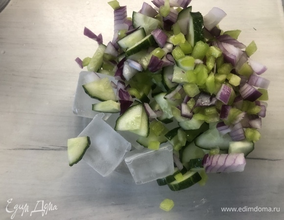 Нарезаем огурец, оставшийся болгарский перец и красный лук небольшими кубиками, выкладываем в емкость, где будем охлаждать суп с частью льда.