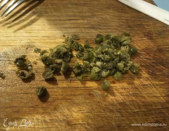 Пока отвариваются картофель и яйца, подготовим заправку для салата. Каперсы нарезать на 2–4 части.