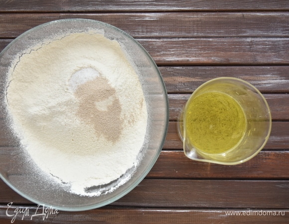 Соединить соль и муку, добавить дрожжи и перемешать сухие ингредиенты. В теплой воде растворить сахар, влить оливковое масло.