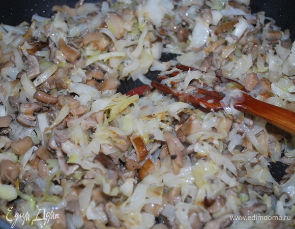 К грибам добавьте нашинкованную капусту и все вместе обжаривайте примерно 8–10 минут. Добавьте черный перец и специи по вкусу.
