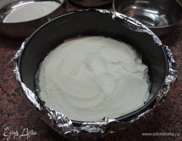Разъемную форму (20 см в диаметре) застелить бумагой для выпечки, бортики смазать маслом. Форму поставить на противень или обернуть фольгой, поскольку сок может вытечь. Высыпать одну часть сухой смеси.