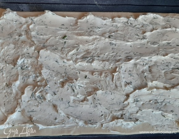 Раскатываем пласт теста, смазываем сырно-сметанной смесью.