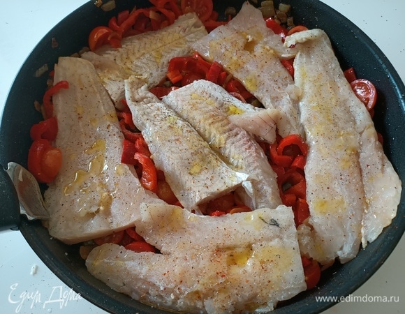 Филе трески укладываем между овощами, посыпаем солью, перцем, поливаем филе оливковым маслом. Накрываем крышкой и тушим 5 минут. Затем рыбу переворачиваем, при необходимости добавляем немного воды и тушим еще 5–7 минут.