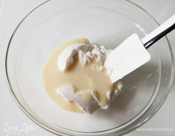 К творогу добавить сгущенное молоко и хорошо перемешать.