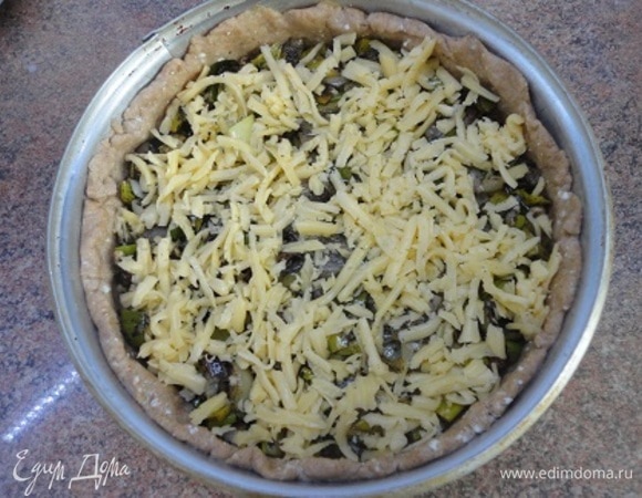 Выложите луковую начинку и посыпьте оставшимся сыром.