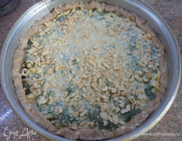 Вылейте заливку и посыпьте оставшимся арахисом. Выпекать 35–40 минут при температуре 190°C.