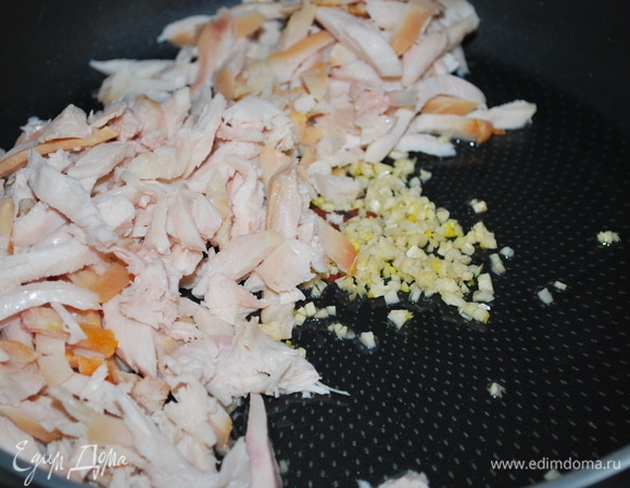 На оливковом масле обжарьте чеснок и копченую курицу, нарезанную на кусочки, примерно 3–4 минуты.