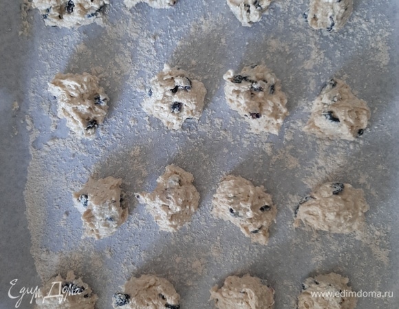 Муку, творог, яйца, разрыхлитель смешать и пробить блендером до образования однородной массы, добавить предварительно замоченный в теплой воде изюм, хорошо перемешать и выкладывать на противень ложкой. Использовать для выпекания пергаментную бумагу не рекомендую, т. к. печенье неизбежно прилипнет, независимо от обработки поверхности маслом и т. д.