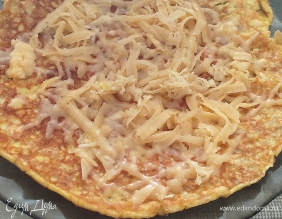 Пока овсяноблин еще горячий, посыпаем его сверху тертым сыром, также можно использовать творожный или плавленый сыр. По вкусу можно добавить немного чеснока.