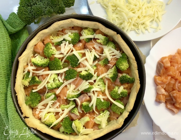 На дно готовой основы выложить немного натертого сыра. У меня моцарелла. Затем — кусочки красной рыбы. Далее — брокколи.