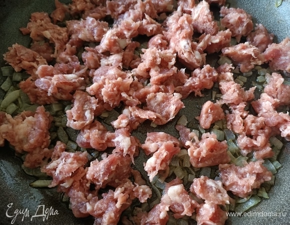 С колбасок снимаем оболочку и отправляем в сковороду к луку. Обжариваем 2–3 минуты.