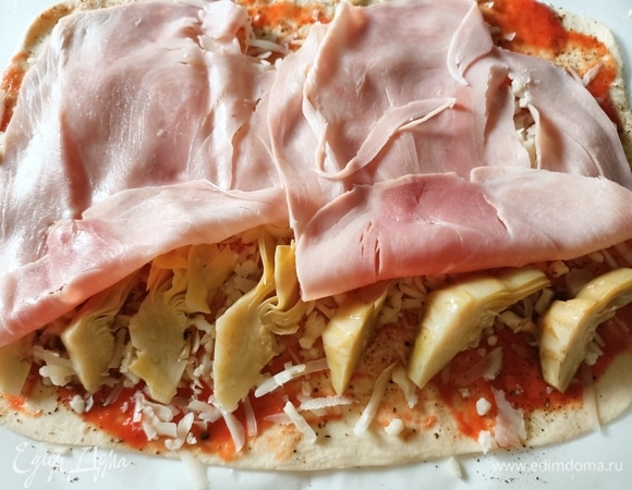 Со второй половиной теста повторить то же самое, только вместо кукурузы выложить ряд артишоков, затем — сыр и ветчину.