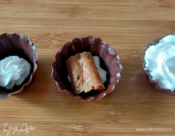 На дно корзинок выложить немного крема, затем печенье, предварительно окунув его в кофе, и снова крем.