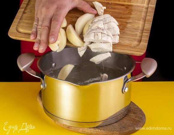 Полуготовую грудку вытащите из кастрюли и мелко порубите. Добавьте в кастрюлю картофель и верните грудку. Посолите и поперчите.