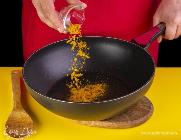 В разогретое на сковороде растительное масло добавьте карри. Хорошо перемешайте.