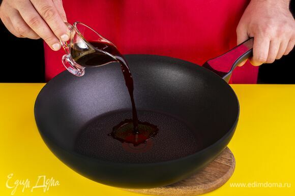 На среднем огне разогрейте сковороду и влейте в нее соевый соус.