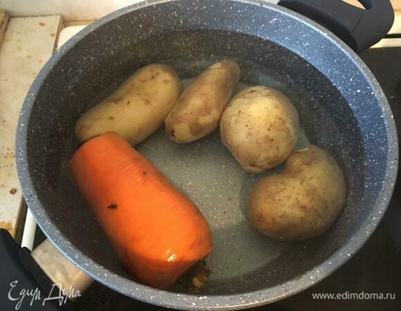 В отдельной кастрюле варим картофель и морковь до мягкости, так же — в кожуре. Солим, готовность проверяем вилкой или ножом. Варить примерно полчаса.<br />
Солить овощи предлагаю только на этом этапе, остальной соли хватит в салате благодаря сельди и майонезу. Отдельно отвариваем яйца до полной готовности (10 минут после закипания). Все сваренные ингредиенты остудить.