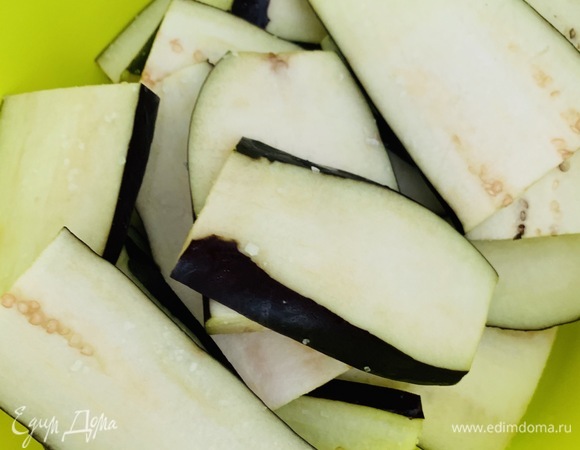 Мытые баклажаны со шкуркой разрезаем вдоль на дольки. Слегка солим и оставляем на 10 минут, чтобы ушла горечь.