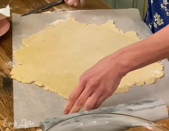 Выложить тесто на лист бумаги для выпечки и раскатать в тонкий корж.