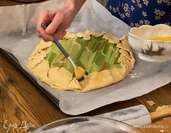 Оставшееся яйцо взбить и смазать края тарта, ревень посыпать 1 ч. ложкой сахарной пудры. 