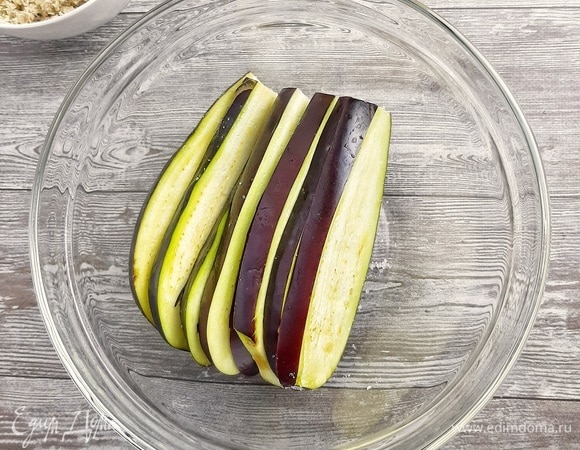 Баклажан разрезать на слайсы. Должно получиться 8 штук, без учета боковых с кожурой. Солим их и оставляем минут на 10.