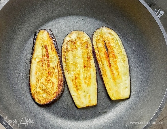 Затем сливаем образовавшуюся жидкость. Добавляем немного растительного масла, перемешиваем. Обжариваем баклажаны на сухой сковороде с двух сторон до румяности (огонь средний). Даем баклажанам остыть.