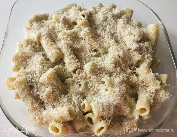 Пасту соединить с соусом, перемешать и выложить в форму для запекания. Сверху посыпать тертым сыром и запекать 15 минут.