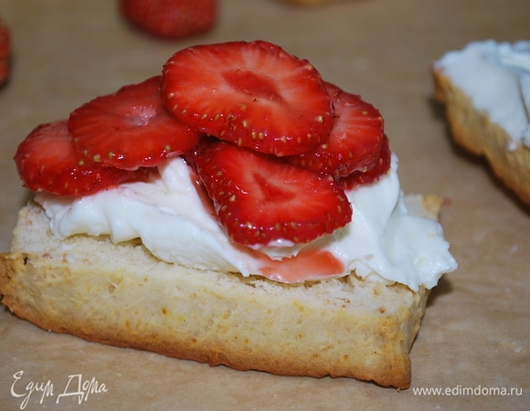 Сверху сыра выложите кусочки клубники, полейте сиропом и украсьте листиком мяты.