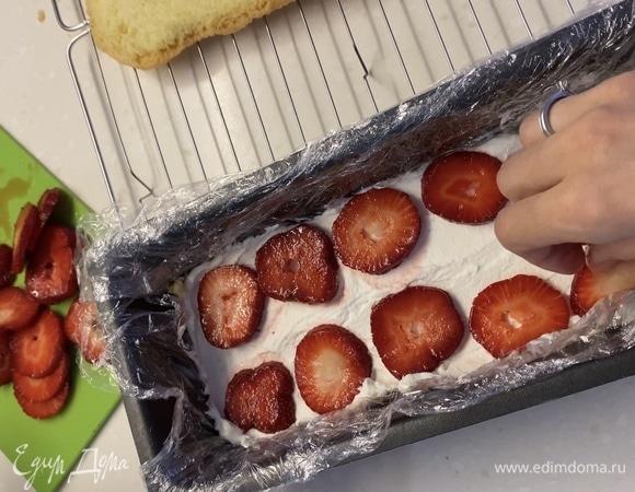 Клубнику нарезать на кружочки одинаковой толщины. Начинаем собирать торт. Форму, которую вы выберете, застелить внутри пищевой пленкой. На дно положить первый корж, распределить сверху крем, следом клубнику. Так проделать с каждым слоем. Сверху накрыть пищевой пленкой и убрать в холодильник минимум на 2 часа.