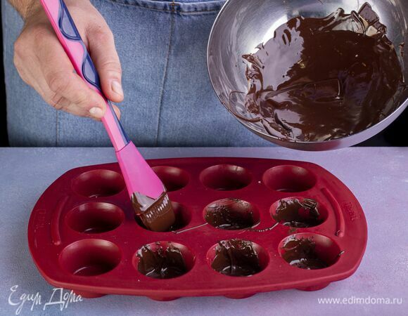 Смажьте растопленным шоколадом силиконовые формочки при помощи кухонной кисти. Уберите в морозилку на 15 минут.