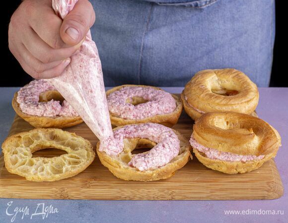 Остывшие кольца разрежьте пополам и наполните кремом, используя кондитерский мешок.