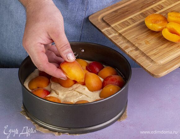 Тесто выложите в форму, застеленную пергаментом. Выложите абрикосы.