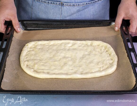 Раскатайте тесто в виде прямоугольника. Перенесите тесто на противень, застеленный пергаментной бумагой.