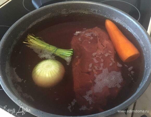 Первым делом ставим вариться мясо (у меня это было полкило говядины без костей) в пятилитровой кастрюле. Мяса можно взять меньше, но для меня в харчо основной ингредиент — все же мясо. К мясу в кастрюлю добавляем целую луковицу, морковку и стебли кинзы, перевязанные нитью. Закрываем крышкой, ставим на средний огонь и забываем на час-два, в зависимости от того, какую часть мяса вы варите. Ценители скажут, что с бульона нужно снимать пену или после процедить его, — на ваше усмотрение.