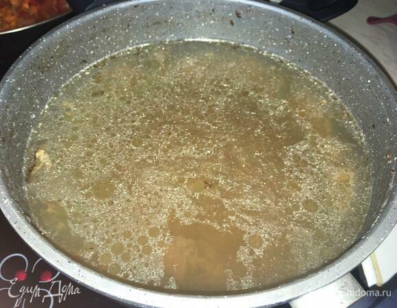 В мясной бульон добавляем рис и нарезанное кусками мясо, закрываем крышкой, доводим до кипения, варим 10 минут на среднем огне.