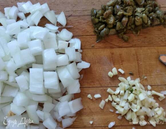 Нарезать мелко лук. Нашинковать чеснок и каперсы. В растительном масле спассеровать лук до прозрачности, добавить чеснок, каперсы и сухой розмарин. Пассеровать еще пару минут.