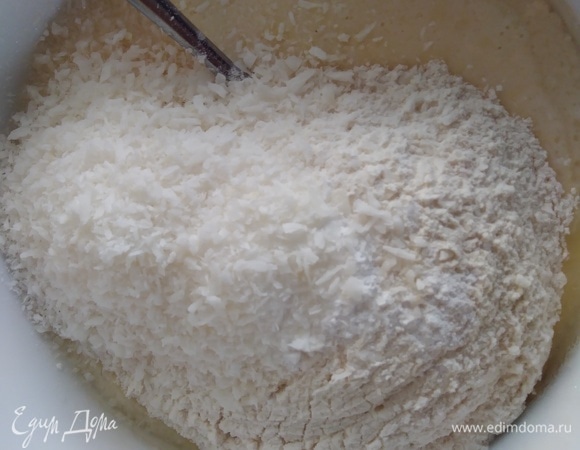 Просеять муку, соду и разрыхлитель. Отмерить кокосовую стружку. Всыпать к яичной смеси и хорошо перемешать.