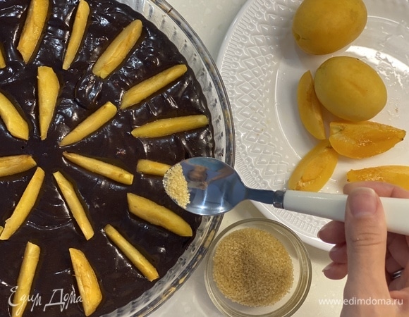 Сверху выложить нарезанные абрикосы. Посыпать их коричневым сахаром. Выпекать при 170°C 20–25 минут.