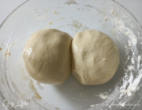 Разделяем тесто на две равные части, еще немного вымешиваем каждую часть, смазываем оливковым маслом, накрываем пищевой пленкой и оставляем на два часа при комнатной температуре.