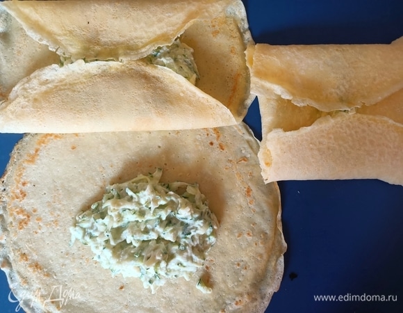 Начинку выложить на середину блинчика. Завернуть края блинов внутрь так, чтобы начинка не была видна, придать форму квадрата.