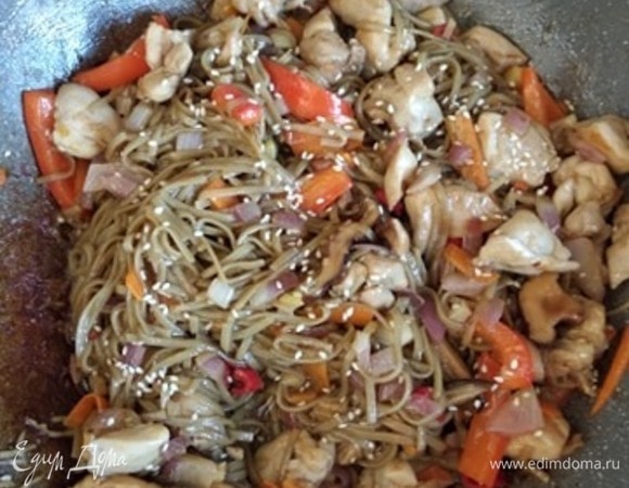 Лапшу откинуть на дуршлаг, промыть холодной водой. Добавить в вок к курице. Влить соус. Солить не надо! Добавить половину кунжута. Все перемешать и обжаривать 1–2 минуты. При подаче посыпать оставшимся кунжутом. Можно посыпать зеленым луком. Приятного аппетита!