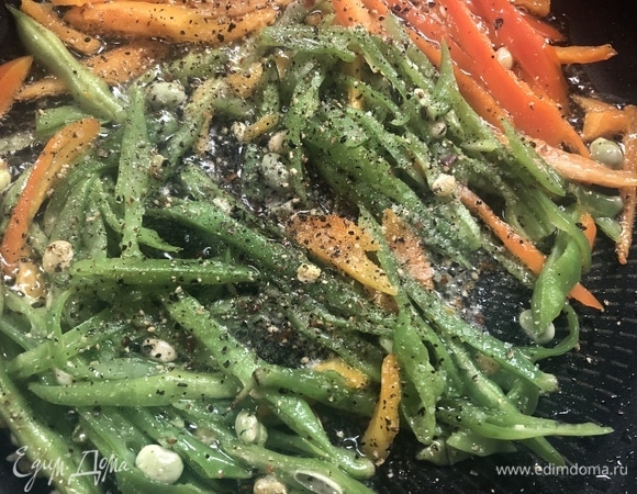 На разогретую сковороду с маслом отправляем фасоль и перец, солим, перчим, жарим 1–2 минуты.