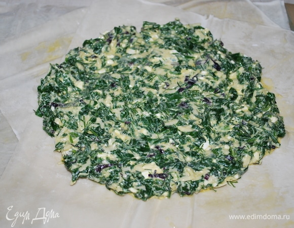 Листы теста фило разложите друг на друга, каждый лист смажьте растопленным сливочным маслом. На середину выложите начинку из шпината, сыра и брынзы.