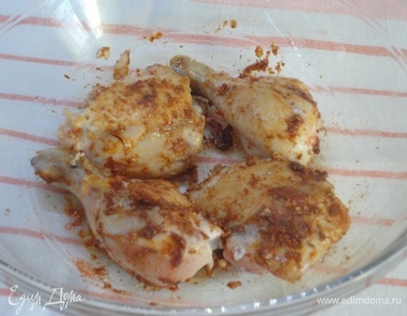 В сковороде, которую можно затем поставить в духовку, разогреть растительное масло и подрумянить курицу со всех сторон. Переложить куски курицы в миску со специями и хорошо их натереть.