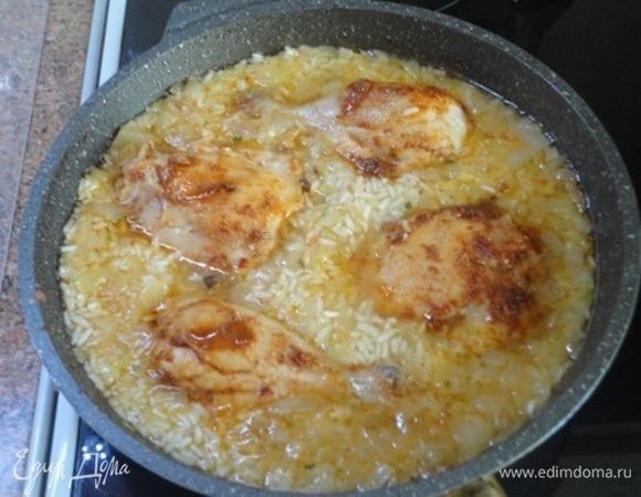 Влить воду или бульон, попробовать на соль и довести все вместе до кипения. Среди риса выложить натертые специями голени и вставить посуду с блюдом в разогретую до 180°C духовку на 20–25 минут, пока рис не впитает всю жидкость и мясо не дойдет до готовности.